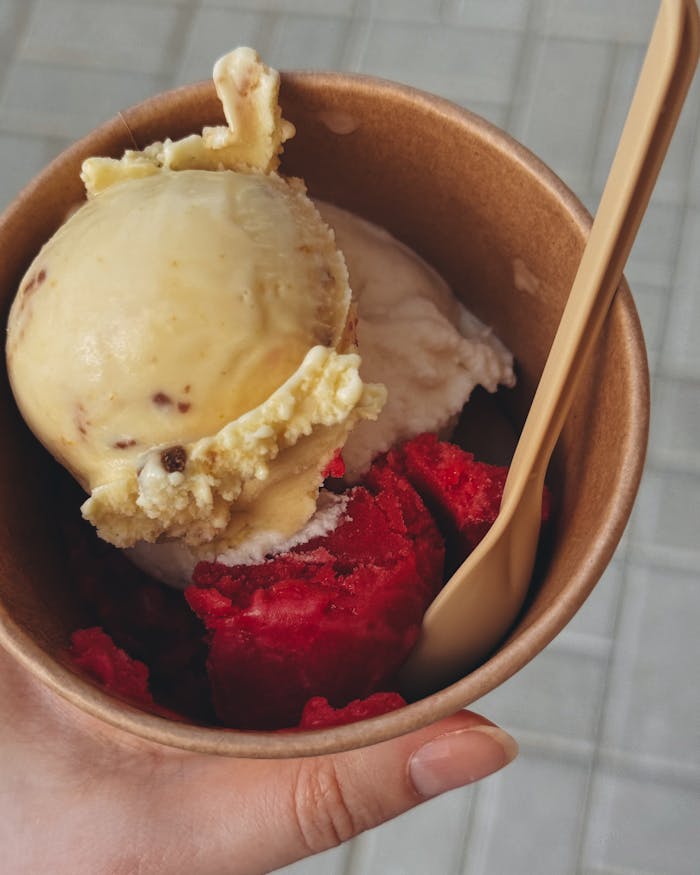 A delicious mix of vanilla and berry ice cream in a biodegradable paper cup.